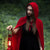 Image of a woman in a forest wearing a red hooded cloak.