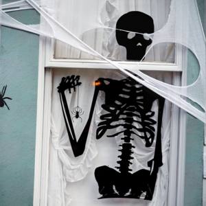 Image of a black skeleton cut out in a white window.