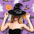 Image of a women wearing a black witch hat.