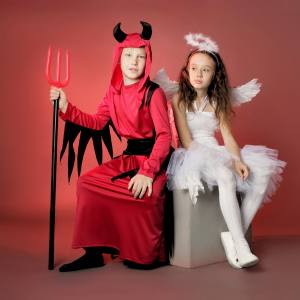 Image of a boy in a devil costumes and a girl in an angel costume