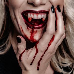 Image of a woman with vampire fangs and fake blood