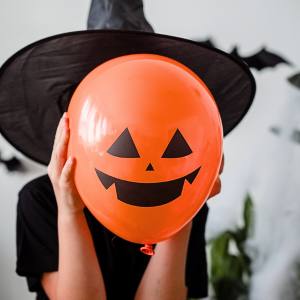 Image of a kid holding an inflatable jack o lantern balloon