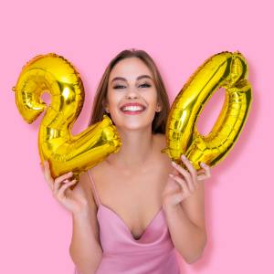 Image of a woman holding gold numbered balloons