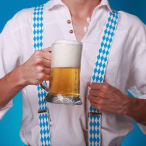 Image of a man holding a beer with suspenders on