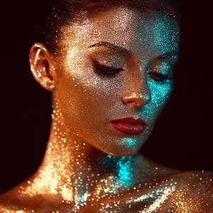 Image of a woman covered in glitter costume makeup