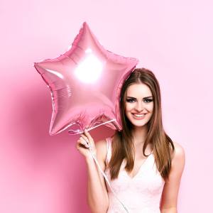 Image of a woman holding a pink star shaped balloon