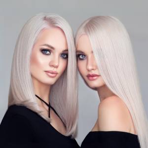 Image of two women wearing straight blonde wigs