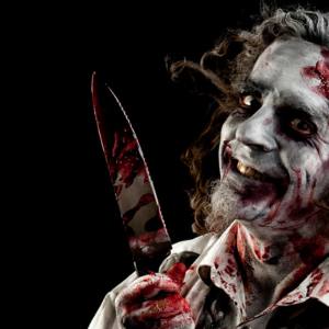 Image of a man dressed like a zombie holding a fake knife