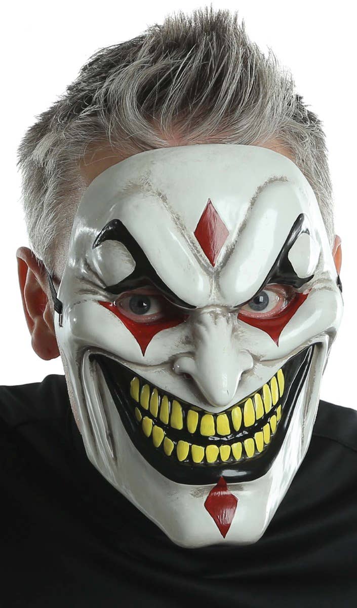 Evil Jester Men's Halloween Plastic Face Mask With Red Diamonds And Black Painted Mouth And Eyebrows Main Image